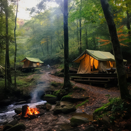two large canvas tents at a campsite in Tenessee along a small stream and a small camp fire